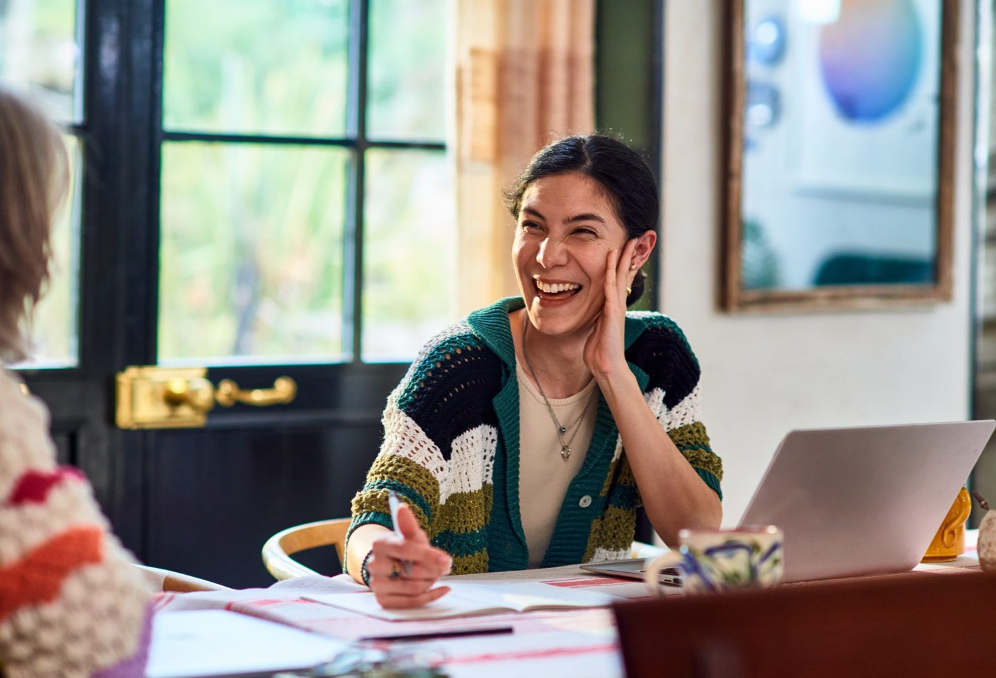 A woman smiling and laughing with a coworker