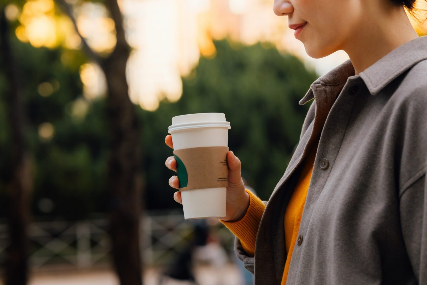 woman holding coffee in a to-go cup