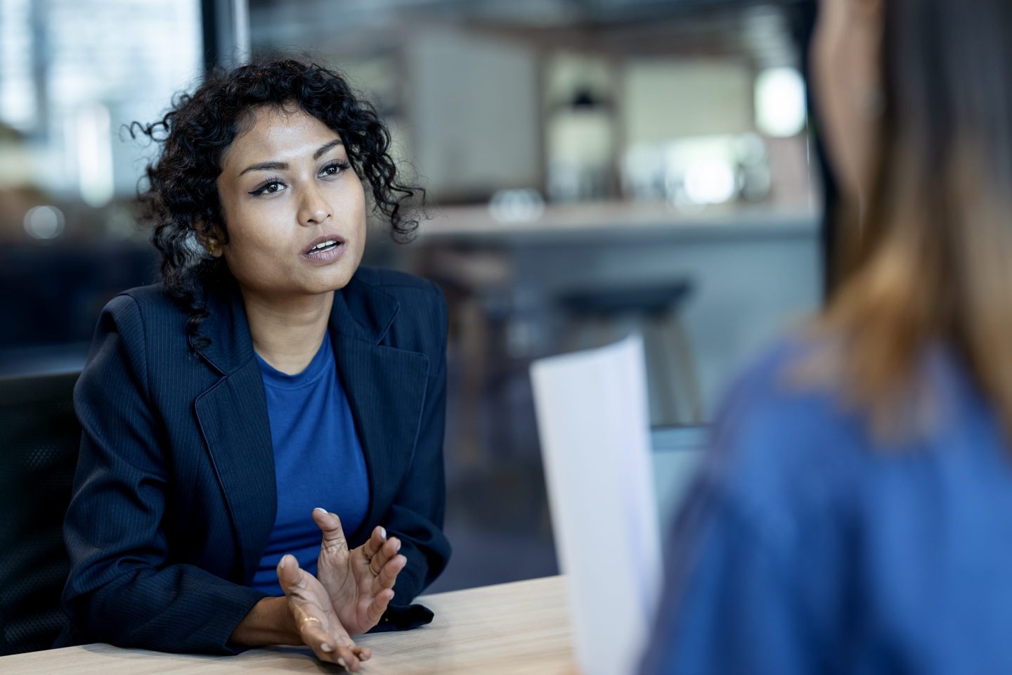 Drive Talent Investments with Strategic Workforce Planning. A female job-seeker answering questions during a job interview with a human resource manager in a business office.