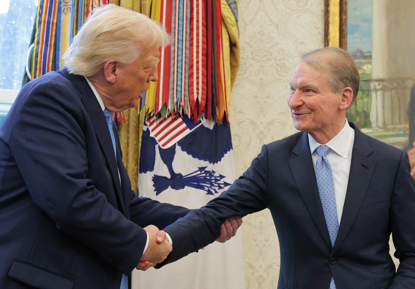U.S. President Donald Trump shakes hands with Securities and Exchange Commission Chairman Paul Atkins during Atkins' swearing-in ceremony in the Oval Office at the White House on April 22, 2025 in Washington, DC.