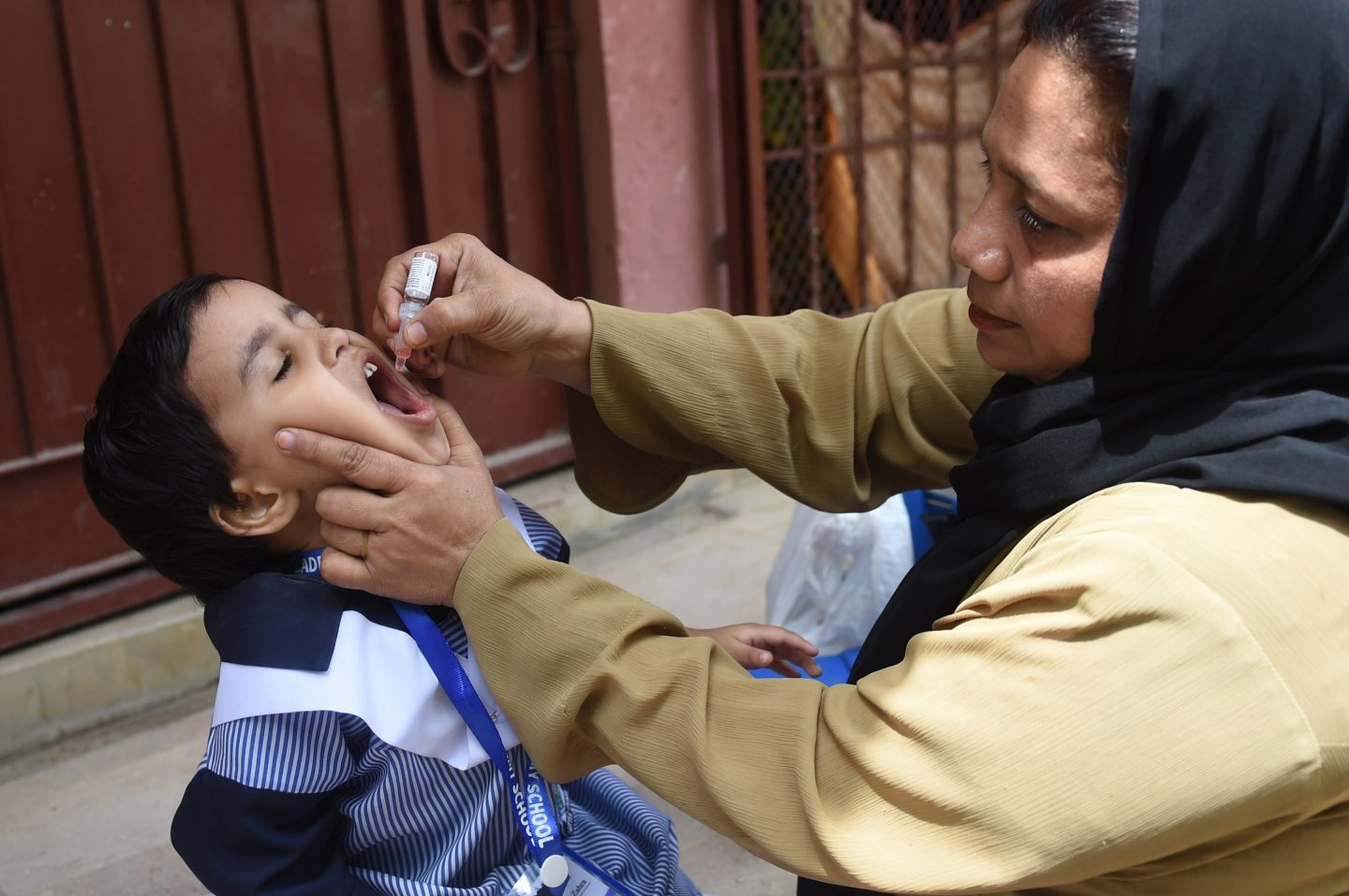 A Pakistani health worker administers polio drops to a child during a polio vaccination campaign in Karachi on April 18, 2016.
US philanthropist Bill Gates said that "with any luck" polio will be eradicated by 2017 in the last two countries where it remains active, Pakistan and Afghanistan. / AFP / RIZWAN TABASSUM (Photo credit should read RIZWAN TABASSUM/AFP via Getty Images)